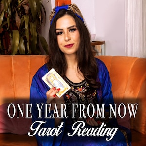 May include: A woman wearing a blue and gold patterned robe holds a tarot card in front of an orange couch. The text "ONE YEAR FROM NOW Tarot Reading" is displayed below her.