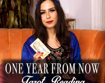 May include: A woman wearing a blue and gold patterned robe holds a tarot card in front of an orange sofa. The text "ONE YEAR FROM NOW Tarot Reading" is displayed below her.