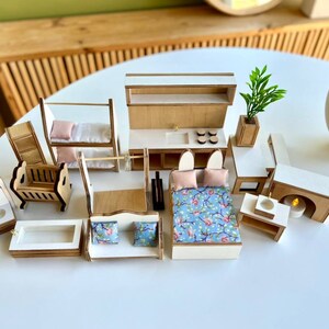 Puede incluir: Un conjunto de muebles en miniatura para casa de mu&ntilde;ecas con acabado blanco y madera. El conjunto incluye una cama, una cuna, una litera, un sof&aacute;, un inodoro, una ba&ntilde;era, un lavabo, una chimenea y una planta.