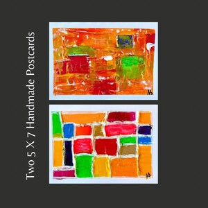 May include: Two 5 x 7 inch handmade postcards with abstract geometric designs. The first postcard features a colorful abstract design with orange, red, yellow, green, and blue paint. The second postcard features a similar design with a more defined grid pattern.