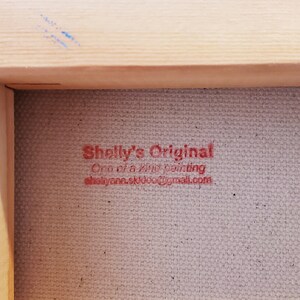 May include: Close-up of a red stamp on a canvas surface that reads "Shelly's Original One of a kind painting shellyannaskul@gmail.com"