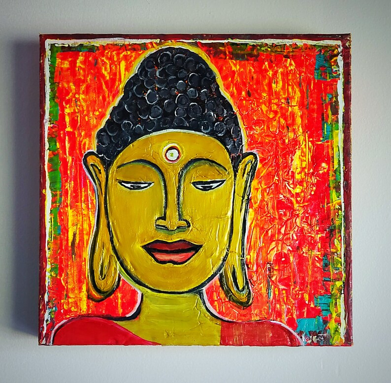 May include: A painting of a Buddha with a yellow face and a black and white headdress. The background is a vibrant orange and red with hints of yellow and green.