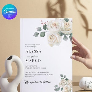May include: White wedding invitation with a floral design featuring white roses and green leaves. The text reads "You are warmly invited to the wedding of Alyssa and Marco. Sat | 17 | Aug Twenty Twenty XXXX The Breakers, Palm Beach, FL 1 South County Road Palm Beach, FL 33480 United States Reception to follow"