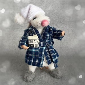 May include: A handmade felt mouse wearing a blue plaid robe, white nightcap, and gray slippers. The mouse holds a small paper item with the number 24 on it. The background is a soft gray with white heart shapes.