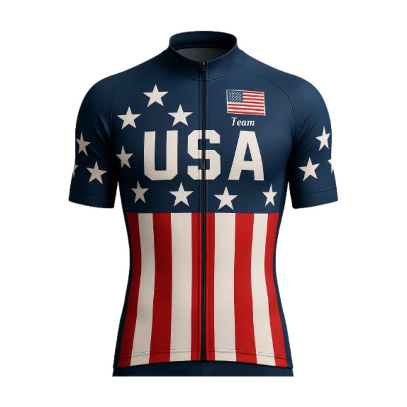 May include: A blue cycling jersey with a white zipper and short sleeves. The jersey has a red, white, and blue American flag design with white stars and the word 'USA' in white letters. The jersey also has a small American flag on the right shoulder with the word 'Team' underneath it.