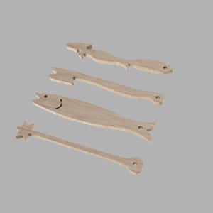 May include: Four light brown wooden kitchen utensils. The set includes a mermaid, a fork, a fish with a smiling face, and a star-shaped wand. Each utensil has a hole for hanging, ideal for a kitchen.