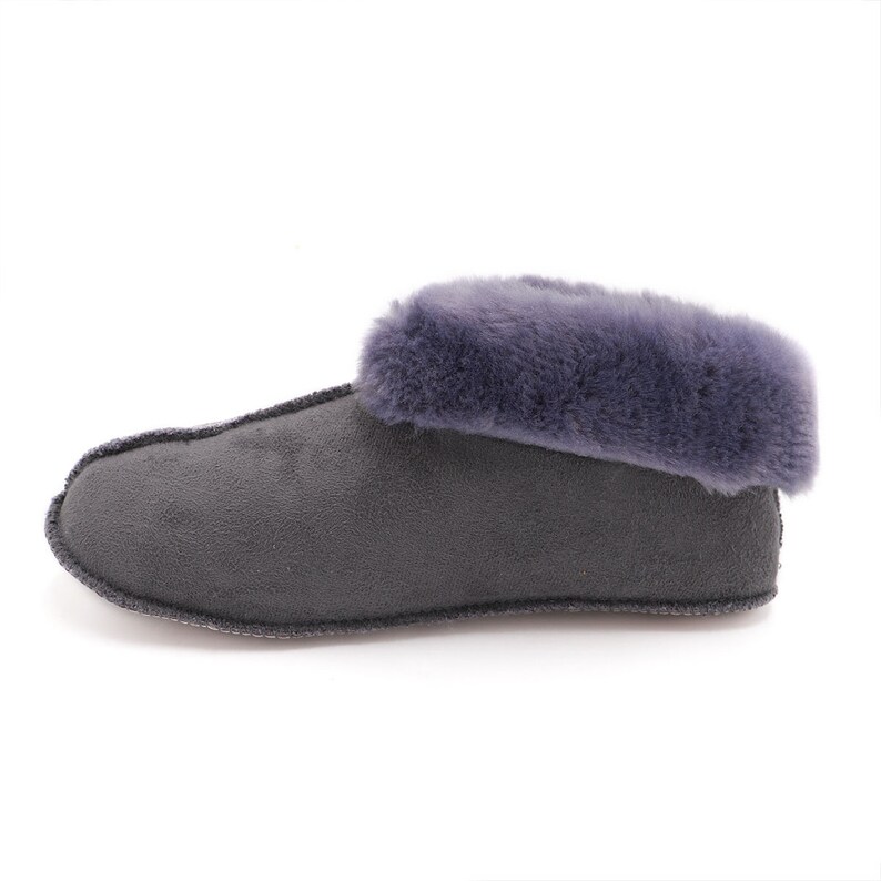 Op de afbeelding: Grijze su&egrave;de pantoffel met een zachte, donzige grijze rand rond de bovenkant.