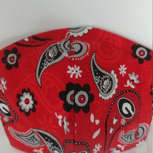 May include: Red face mask with a paisley pattern featuring a white and gray floral design and the University of Georgia logo.