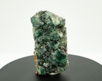 May include: A cluster of green fluorite crystals with a rough, natural texture. The crystals are arranged in a random pattern, creating a unique and interesting display.