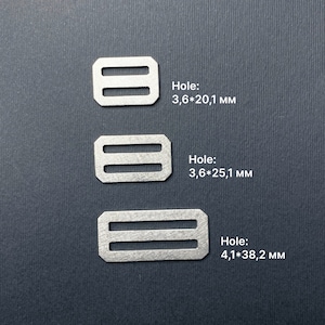 May include: Three silver metal slider buckles with different hole sizes. The top buckle has a hole size of 3.6 by 20.1 mm, the middle buckle has a hole size of 3.6 by 25.1 mm, and the bottom buckle has a hole size of 4.1 by 38.2 mm.