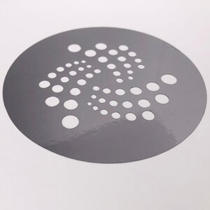 Pu&ograve; includere: Uno stencil circolare grigio con un motivo bianco di punti disposti in forma circolare.