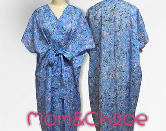 May include: A blue and pink floral print wrap dress with a V-neck and short sleeves. The dress has a tie at the waist and is made of a lightweight fabric. The dress is photographed on a mannequin.
