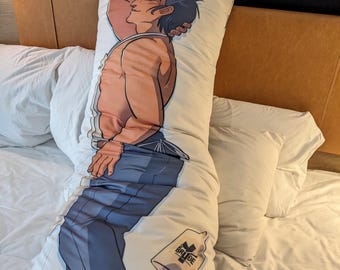 May include: A long, white body pillow featuring a muscular anime-style character in a relaxed pose. The character has dark hair and is wearing blue pants and a white tank top. A logo is printed on the bottom of the pillow.