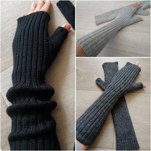 May include: Two pairs of fingerless arm warmers. One pair is black and the other is gray. Both pairs are made of a soft, knitted fabric.