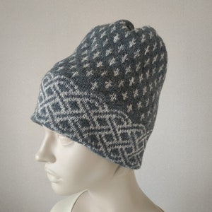May include: Gray knitted beanie with a white geometric pattern. The beanie is made of a soft, warm material and has a comfortable fit.