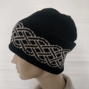 May include: Black knitted beanie with a white geometric pattern around the brim.