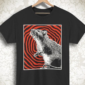 May include: Black t-shirt with a graphic of a white rat in a red and white spiral pattern.