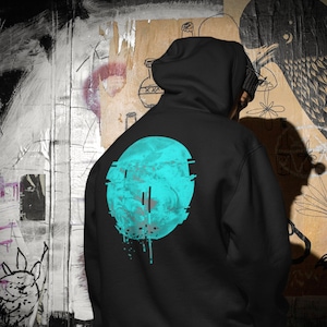 May include: Black hooded sweatshirt with a blue and white graphic of a circle with a glitch effect. The circle is dripping with blue paint.