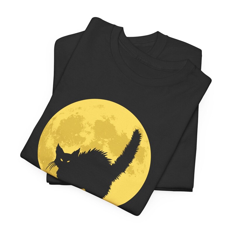 May include: Black t-shirt with a silhouette of a black cat in front of a yellow full moon.