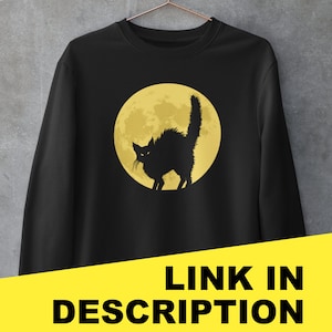 May include: Black sweatshirt with a graphic of a black cat silhouetted against a yellow full moon.