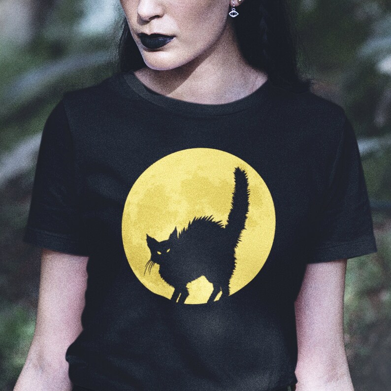 May include: Black t-shirt with a yellow moon and a black cat silhouette.