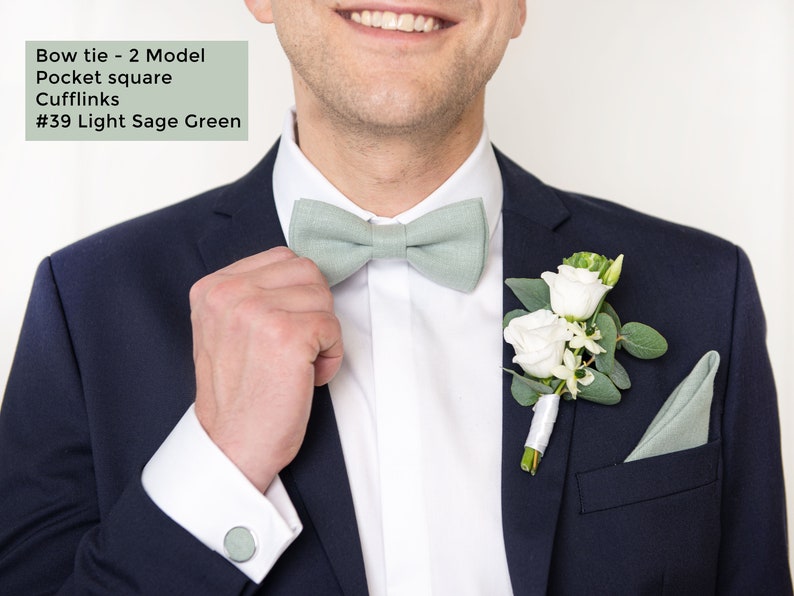 The front-view model with dark blue suit wears the Light sage green color linen pretied bow tie 2 Model, pocket square, and cufflinks.