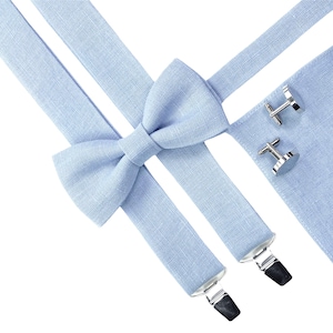 Può includere: Un papillon e bretelle abbinate di colore azzurro chiaro con gemelli d'argento. Il papillon e le bretelle sono realizzati in tessuto di lino.