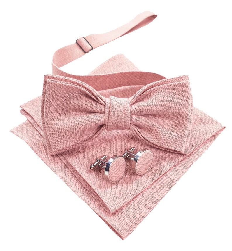 Blush Pink color pre-tied bow tie shown with the same color cufflinks and folded pocket square.
