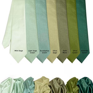 Puede incluir: Una colección de ocho corbatas en varios tonos de verde, desde verde menta claro hasta verde esmeralda oscuro. Cada corbata se muestra con su nombre de color: Mint Sage, Light Sage Green, Eucalyptus Green, Olive Sage, Dark Moss, Olive Green y Emerald Green.