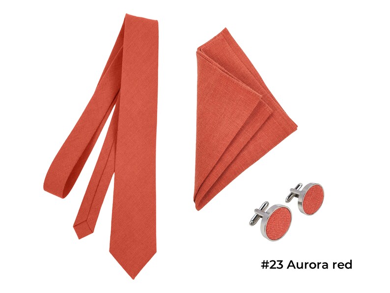 Aurora Red color linen wrapped necktie, metal cufflinks with aurora red color linen detail in the middle, and folded pocket square.