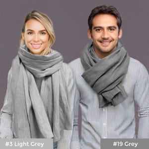 May include: Two people wearing gray linen scarves. The scarf on the left is a lighter shade of gray and is labeled #3 Light Grey. The scarf on the right is a darker shade of gray and is labeled #19 Grey.