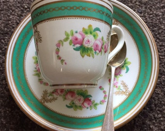 Beautiful, old, delicate bone china coffee cup and saucer, with a silver spoon