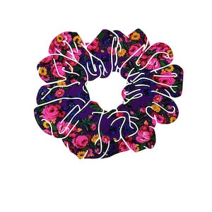May include: A floral scrunchie with a vibrant pattern of pink roses, yellow and blue flowers on a deep purple background. The scrunchie is a circular shape with a white outline, perfect for accessorizing hairstyles.