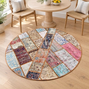 May include: A round area rug featuring a patchwork design composed of various rectangular segments in diverse colours including pink, blue, red, orange, and beige. The rug displays intricate floral and geometric patterns across its surface.