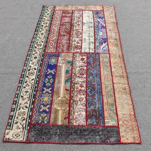 Op de afbeelding: Een kleurrijk patchwork tapijt met verschillende patronen en kleuren, waaronder rood, blauw, groen en wit. Het tapijt is gemaakt van verschillende stukken stof die aan elkaar zijn genaaid.