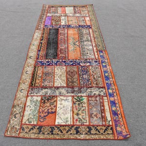 Puede incluir: Una alfombra de patchwork colorida con una variedad de patrones y colores, incluyendo rojo, naranja, azul y verde. La alfombra está hecha de diferentes piezas de tela cosidas juntas.