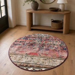May include: A round area rug featuring a distressed, multi-colored pattern with horizontal bands of red, blue, cream, and dark brown. The design incorporates intricate, faded geometric and floral motifs across the entire circular surface.