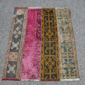Könnte beinhalten: Ein rechteckiger Teppich mit Patchwork-Muster. Der Teppich besteht aus vier verschiedenen Paneelen, jedes mit einem einzigartigen Muster. Die Paneele sind in den Farben Rosa, Braun, Orange und Blau gehalten.