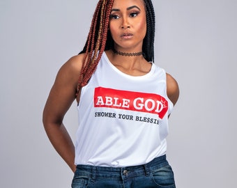 May include: A white tank top with the words "ABLE GOD" in red and "SHOWER YOUR BLESSINGS" in black. The model is wearing blue ripped jeans.