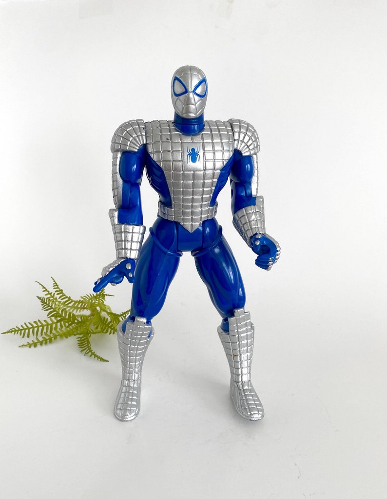 Swing into nostalgia with this Vintage 1995 Toy Biz Spider-Man Action Figure, a must-have for any Marvel enthusiast or action figure collector. Based on the iconic Spider-Man: The Animated Series, this figure captures the web-slinger’s classic look from the mid-‘90s. Standing approximately 11 inches tall, it showcases detailed craftsmanship and articulation, reflecting Toy Biz’s renowned quality from that era.  Classic royal blue, white and silver color.