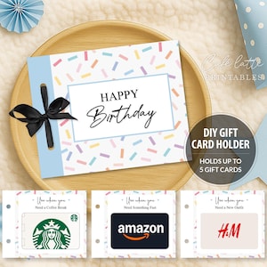 Könnte beinhalten: Ein DIY-Geschenkkartenhalter mit hellblauem Akzent und schwarzem Band. Der Kartenhalter trägt die Aufschrift "HAPPY Birthday" und bietet Platz für bis zu 5 Geschenkkarten. Die gezeigten Geschenkkarten sind für Starbucks, Amazon und H&M.