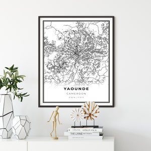 May include: Black and white map print of Yaounde, Cameroon with the city's coordinates, 3°52'N | 11°31'E, printed on white paper and framed in a black frame.