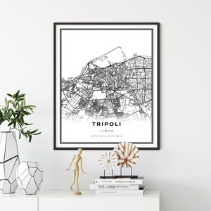 May include: Black and white city map print of Tripoli, Libya with the city name and coordinates in the bottom center of the print. The print is framed in a black frame and is hanging on a white wall.