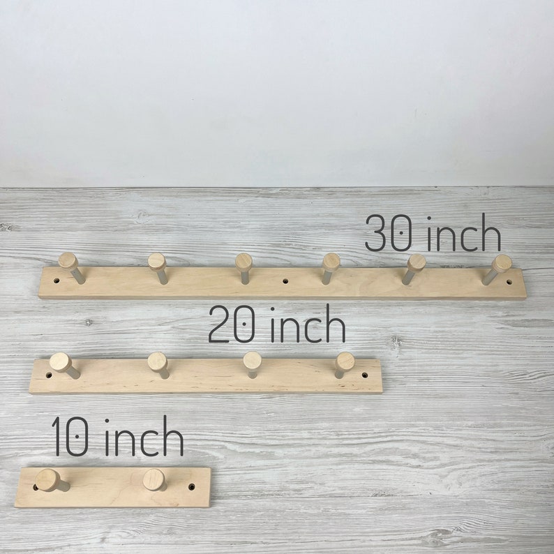 May include: Three wooden coat racks with five hooks each. The racks are 10 inches, 20 inches, and 30 inches long.