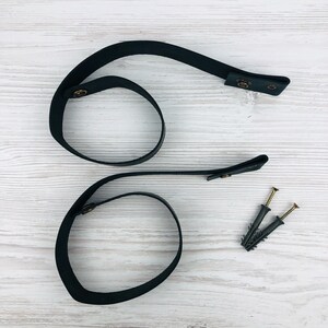 Pu&ograve; includere: Cinturino in pelle nera con accessori in ottone e due viti. Il cinturino &egrave; formato in due cerchi.