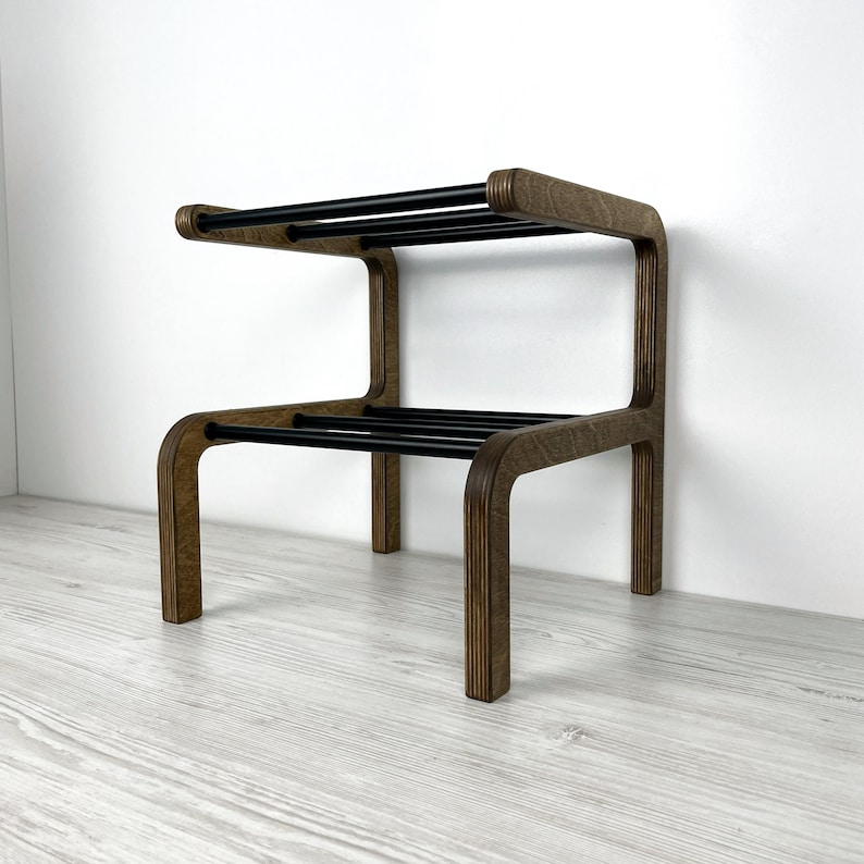 Puede incluir: Una estanter&iacute;a de madera con dos rieles de metal negro. La estanter&iacute;a est&aacute; hecha de madera marr&oacute;n y tiene un dise&ntilde;o moderno.