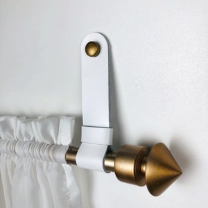 Witte gordijnroedehouder, leren roedebeugels, gordijnriempjes aan de muur