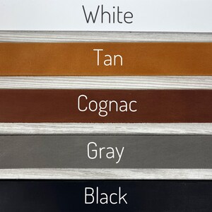 May include: Five leather swatches in different colors: white, tan, cognac, gray, and black.