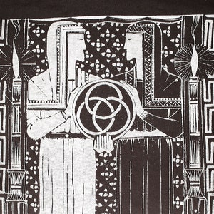 May include: Black and white graphic print of two figures in robes, holding a stylized circle with three overlapping circles inside. The figures are standing in front of a patterned background with a Greek key border.