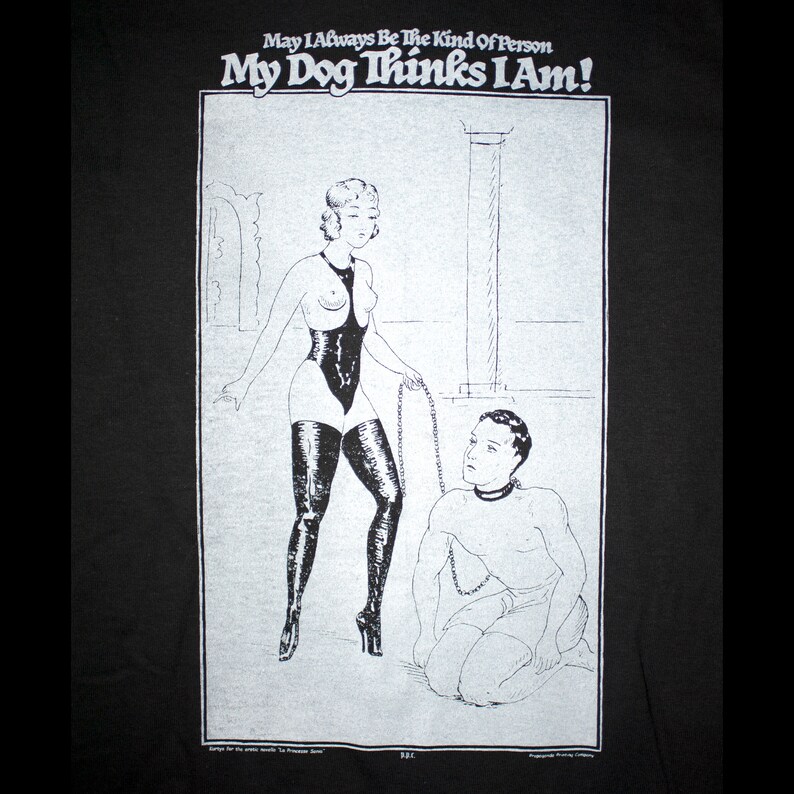 May include: Black and white illustration of a woman in a bodysuit and high heels holding a chain leash. A man is kneeling on the ground with a collar around his neck. The text "May I Always Be The Kind Of Person My Dog Thinks I Am!" is at the top of the image.